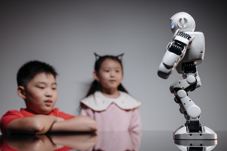 Kids Looking at White Toy Robot on the Table